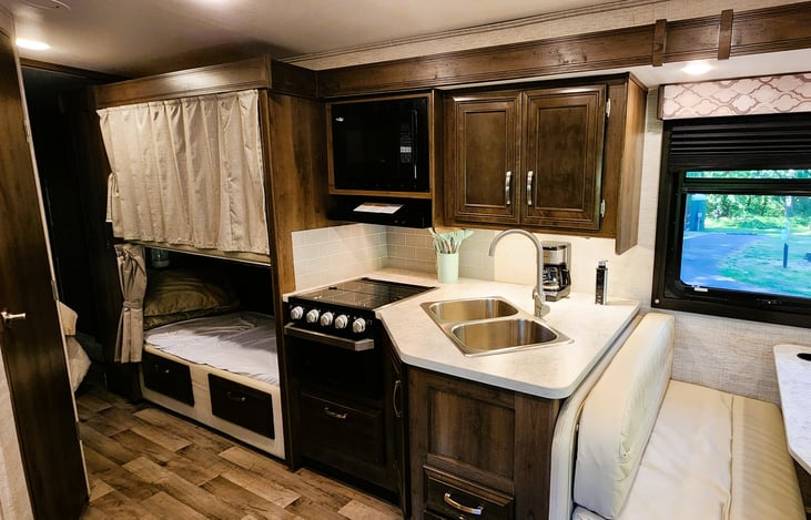 The kitchen is compact but comes equipped with all the utensils you could need, coffee maker, pots n pans, silverware, microwave, double sink, 3 burner stove and oven.