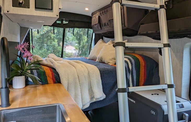 Easily climb the drop-down ladder to your private rooftop pop-top bed, a cozy twin-size space that comfortably fits 2 people—perfect for stargazing or extra sleeping room without sacrificing interior