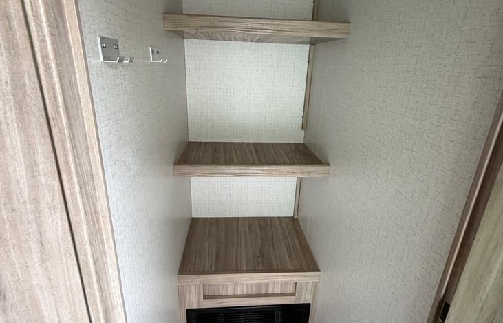 Spacious closet to place your belongings, this is right at the entry way to the travel trailer and has a door to keep those items secured and out of the way