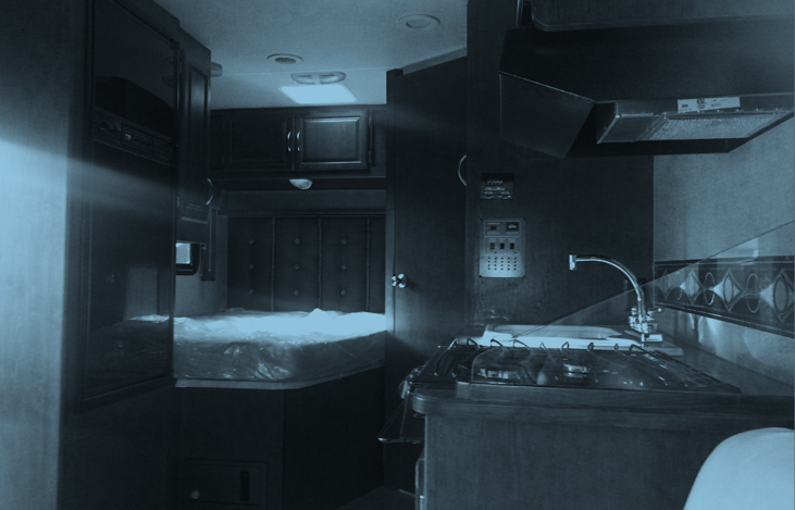 Queen Bed located in the back and nice size fridge near the entrance.