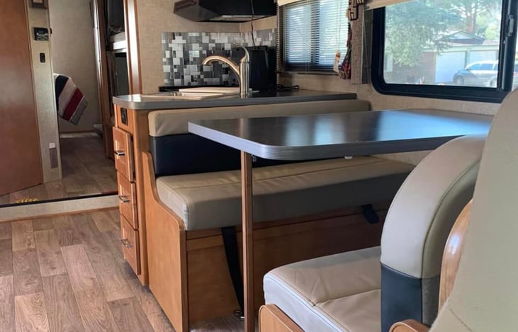 Seating for four at the dinette that can be converted to a bed. Seat belts are available at the table. 

Additional seating on the jack knife sofa. TV is above the table for viewing from the sofa.