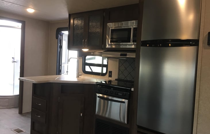 Stainless steel appliances with 3 burner stove and oven.