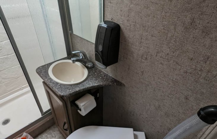 full bath room with sink, toilet and shower.