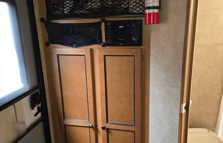 The bedding and towels are stored on top. The bottom is a small closet.