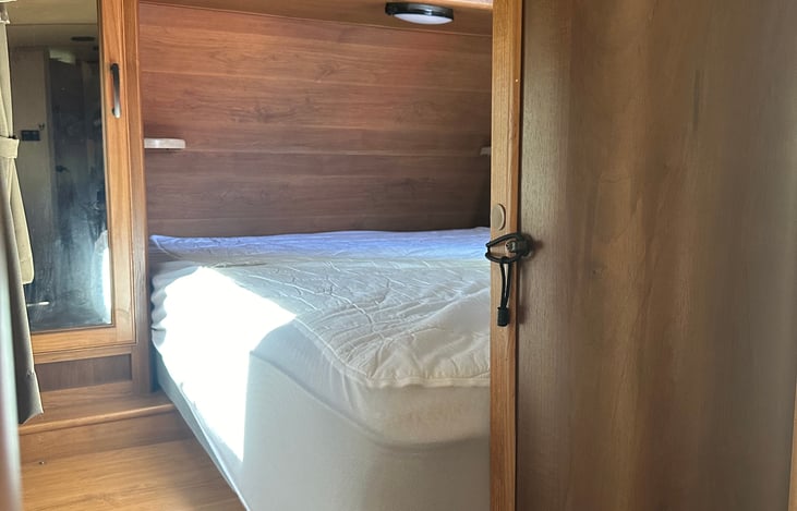 Main bed from left side - shelf and outlet in corner