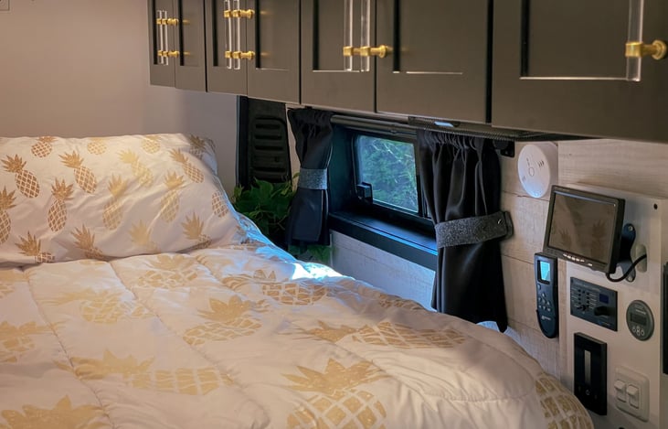 Control center for 4 security cameras on outside, inverter, water pump, water dump, battery monitor, lights, fan remote, and fire / CO detector.