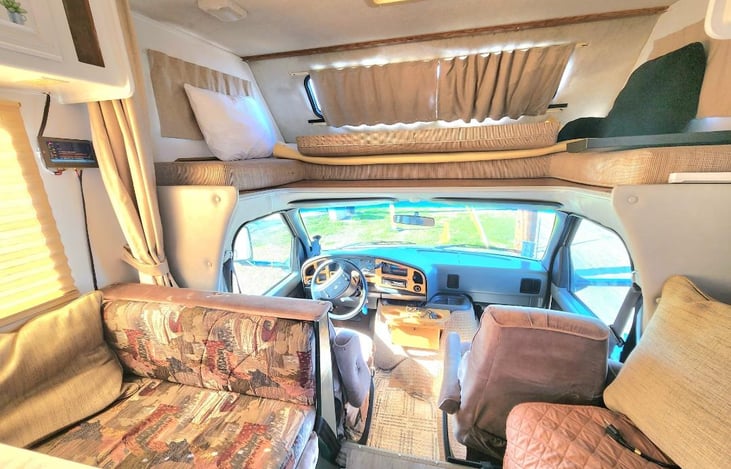 The overhead bed folded up in this picture, but the middle cushion can easy be put down to make this space convert from a twin bed to a queen bed. Use it as a bed or storage. 6 beds total.