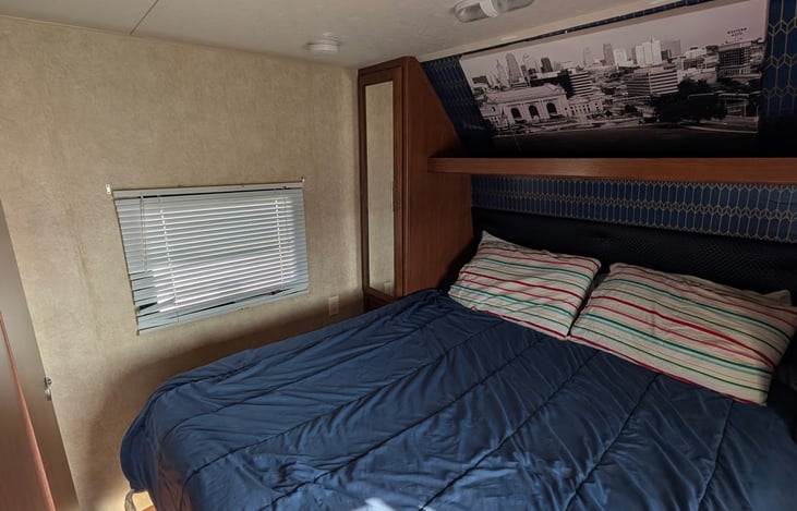 Front primary bedroom with a queen bed, closet space, TV and door closure privacy.