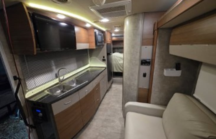 Loveseat/sleeper across from TV.  Generous kitchen space. Dining ware, spices and Keurig coffee maker included, or bring your own.  Comfy queen has residential custom mattress.