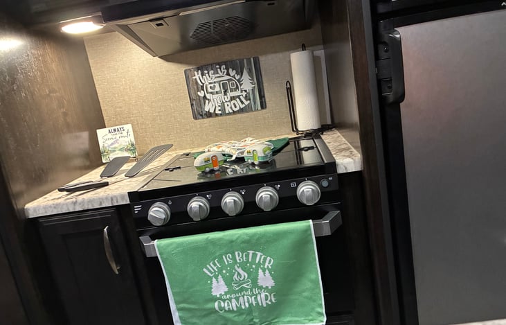 We have spatulas, kitchen towels, hot pads to set pans on, pot holders, pots/pans, a can opener, and a plastic serving tray for some great burgers, dogs, or snacks! Camper has a stove and microwave!