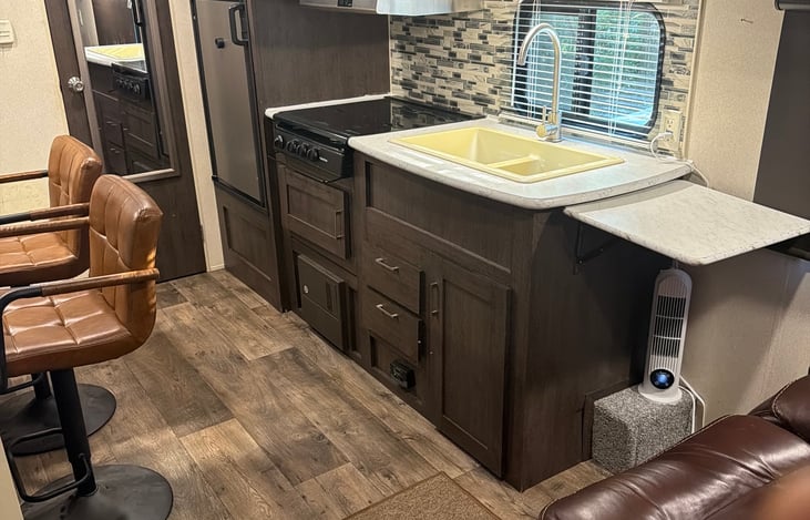 Complete kitchen area with refrigerator, freezer, stove, microwave, and double sink.
