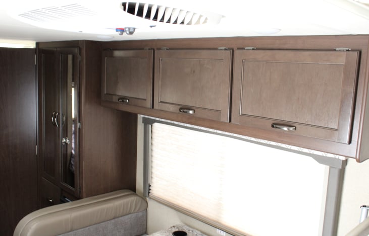 Overhead storage above the dinette includes storage baskets for easy organization.