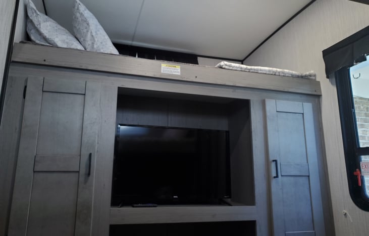 Left side of bunk room sleeps one person with TV.