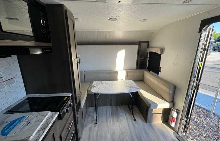 Seating area can be converted to a dining area with a foldable table. Table can be stored in the closet.