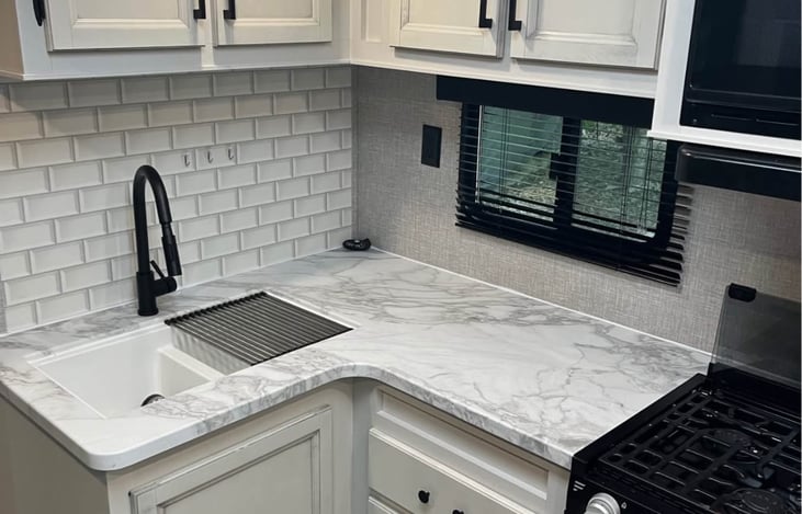 Enjoy a well-equipped kitchen with ample counter space, a propane stove, and an electric microwave. The over-sink storage is filled with all the necessities, for the kitchen.