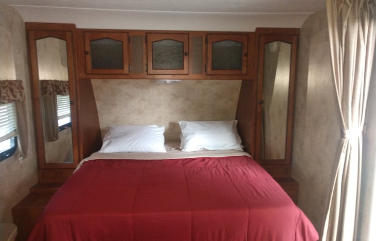 Full/Queen Bed & storage underneath and in cabinets surrounding & a privacy curtain
