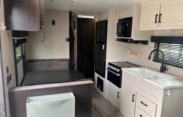 Ktichen with oven, stovetop, microwave, refrigerator and separate freezer, dual sided sink, convertible dinette