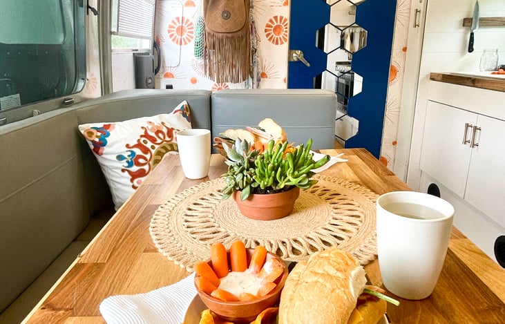 Our gorgeous DFW Airstream rental has upgraded walnut butcher block counter tops and a fully stocked kitchen with a French press coffee maker and smoothie blender. This table collapses to make a bed.