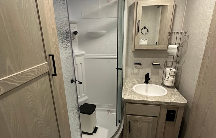 Corner shower, provides enough room for 6' or better to shower easily.