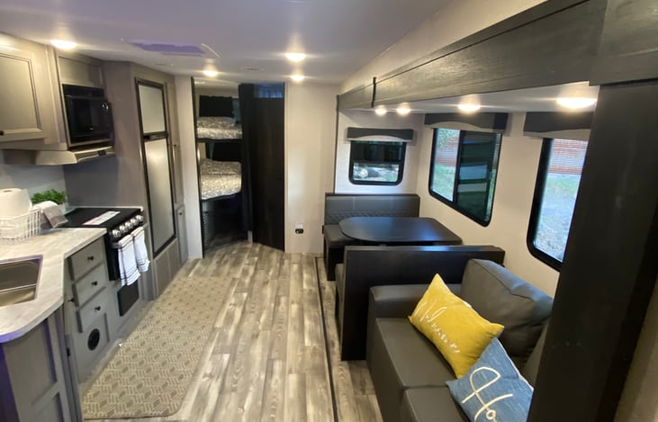 Morning set up. Kitchen, bunks, restroom, dining table and sofa view.