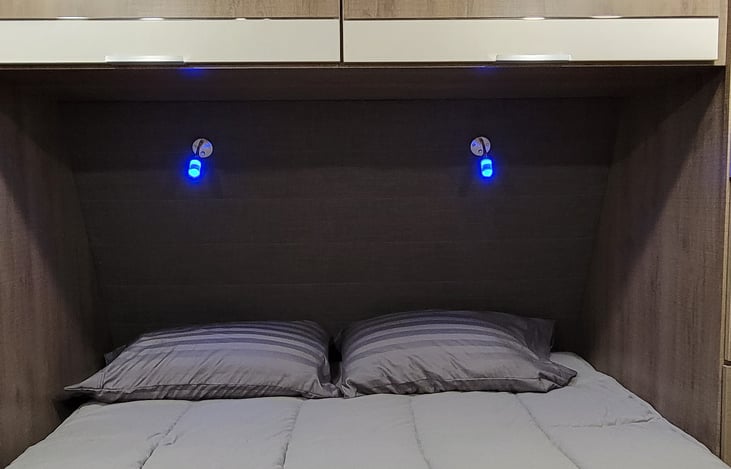 Comfy Sams Club Hotel series bedding and pillows.  Cool blue/white reading lights.