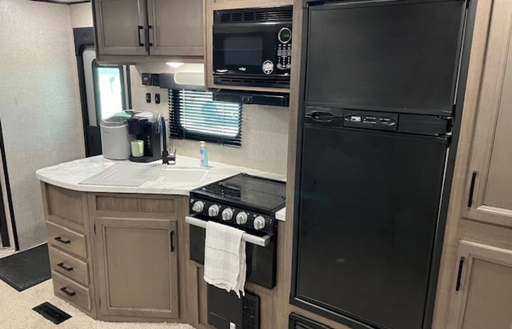 Refrigerator and freezer. 
3- burner stove & oven (gas)
Microwave
Double basin sink
Keurig coffee maker
Instant Ice Maker
Also includes pots, pans, cooking utensils, plates, cups, bowls, etc.