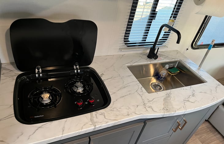 Two burner stove and oversize stainless steel sink.