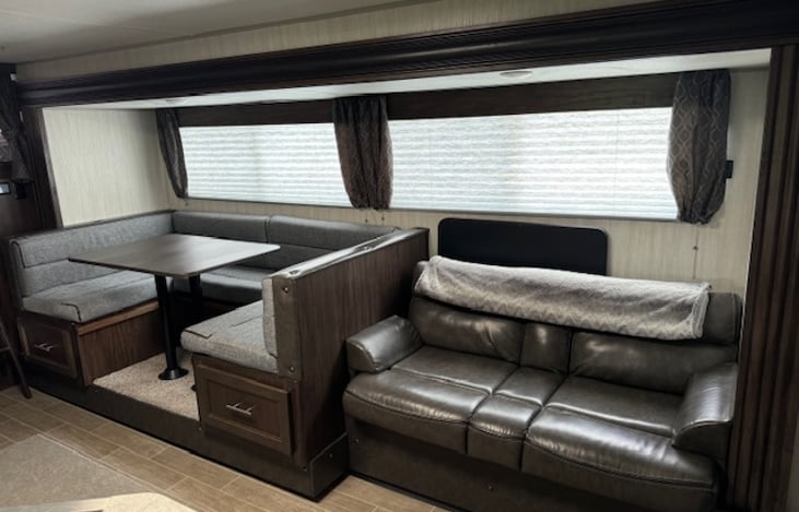 The u-shaped dinette provides seating for the family, while the couch provides even more indoor seating! Both convert to beds as well.