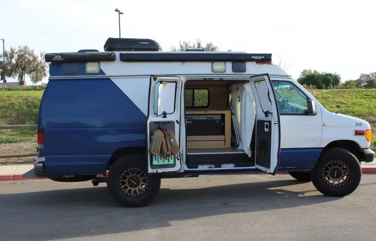 Camp chairs and step stool are hanging on the left side door