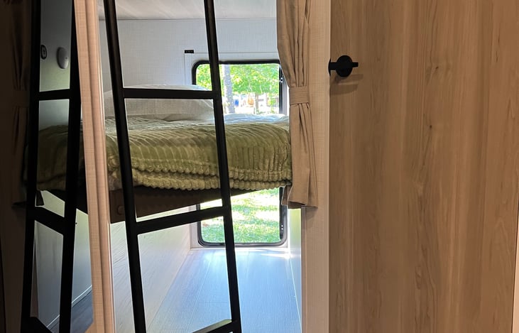 Bottom bunk folds up with large door for oversize storage items like kayaks and bikes.