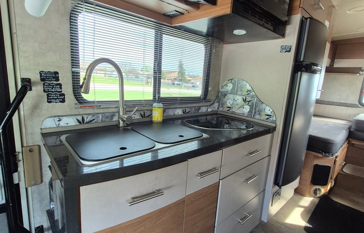 Here is our kitchenette, above is a convection oven and a TV. Please keep food out of the rv tanks. Solid waster should be collected in bags and disposed of in proper trash receptacles.