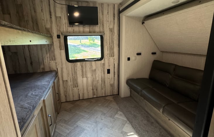 Bunkhouse shown with utilized sofa for watching tv when beds aren’t needed. USB ports available in the wall.