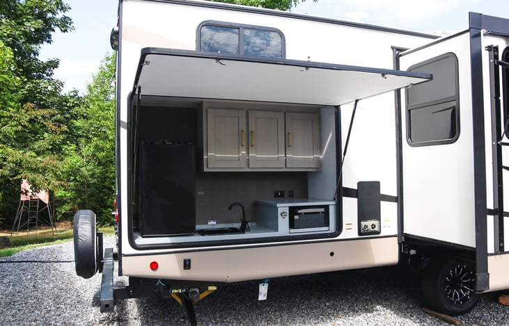 Outdoor Kitchen which includes sink, spacious cabinets and refridgerator.