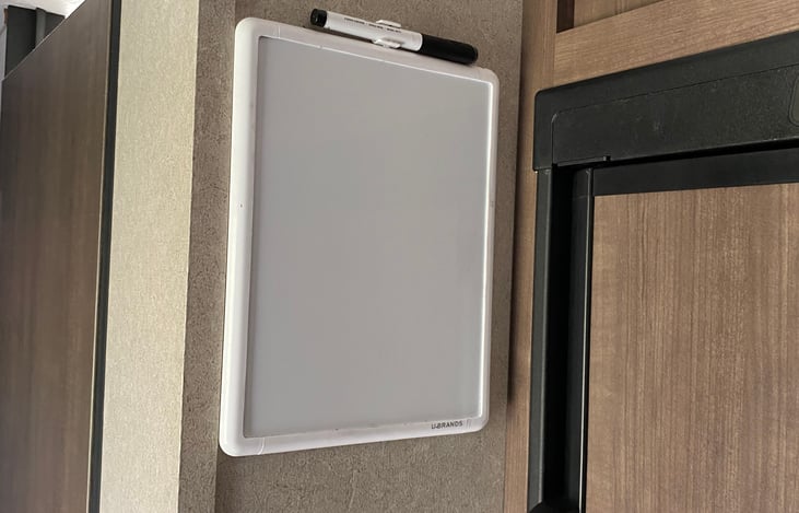 Small whiteboard next to fridge