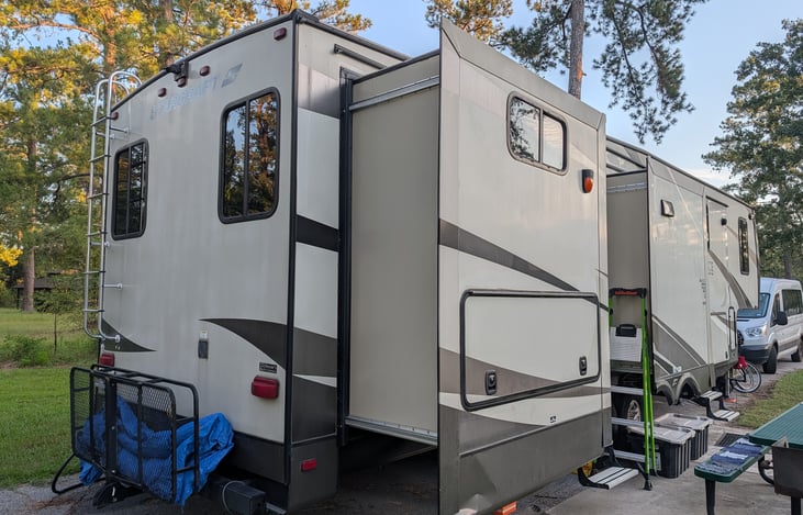The right rear shows the bunkhouse slide with the outside kitchen access. There's a mini-fridge, sink, and extra outlets. Here we keep the grilling utensils, a stick lighter, and some extra supplies.