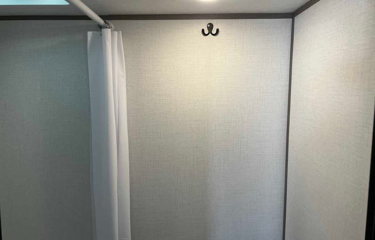 Bathroom with toilet and shower. Includes RV safe toilet paper and Liquified septic treatment