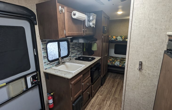 Fully-equipped kitchen includes everything needed to cook up a fun-filled trip! Plus plenty of storage and a HUGE easy-access cabinet next to bunks!
