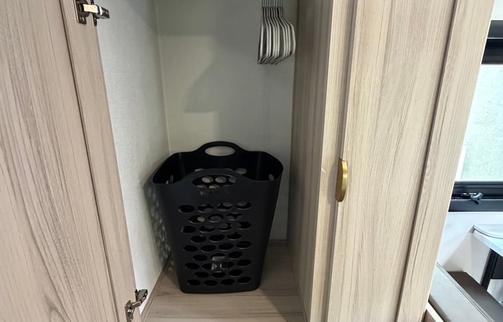 Cabinets include laundry basket and hangars.