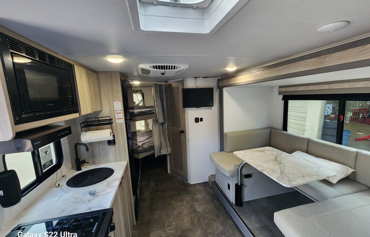 Standing at the front door. You will see a full size dinette, kitchen with stove, microwave, and full size fridge.