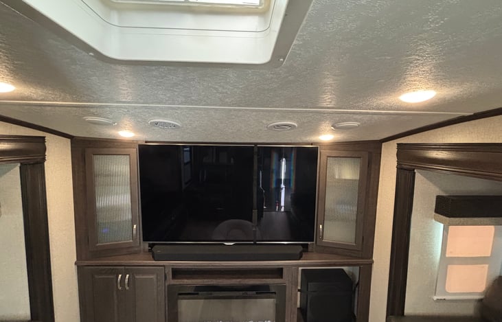 Standing by the theatre seats with heat and massage looking at the 72” 3D TV, fireplace and custom surround sound system for theatre like experience to relax after fun day exploring outside.