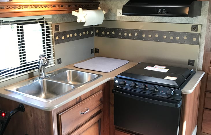 Kitchen area with 3 burner gas stove, gas oven, microwave and kitchen sink.  Plenty of storage!