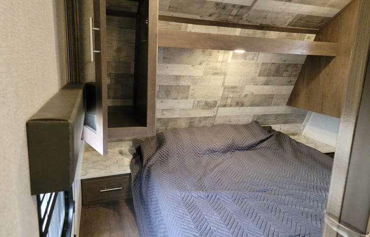 Private bedroom in front of RV.  Armoires and night stand on both sides.  12V charging outlets on both sides.