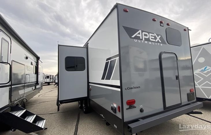 Rear view of rig with access door, brand logo, and slideout open