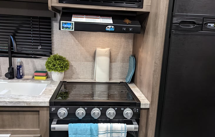 Kitchen with double sinks, stove, oven, microwave, and more