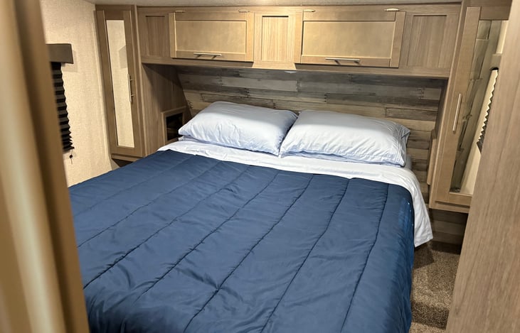 Queen size bed in the master suite. Two small closets with space to hang clothes. USB and plugs available in the cabinets. Storage also available above the bed.