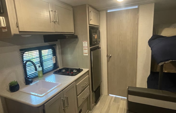 Kitchen with microwave, two burner range, and fridge