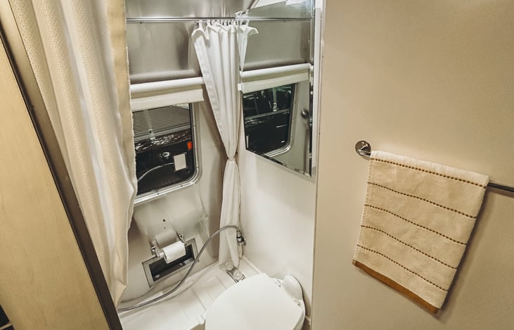 Wet bath including shower and outside access panel for outdoor showering.