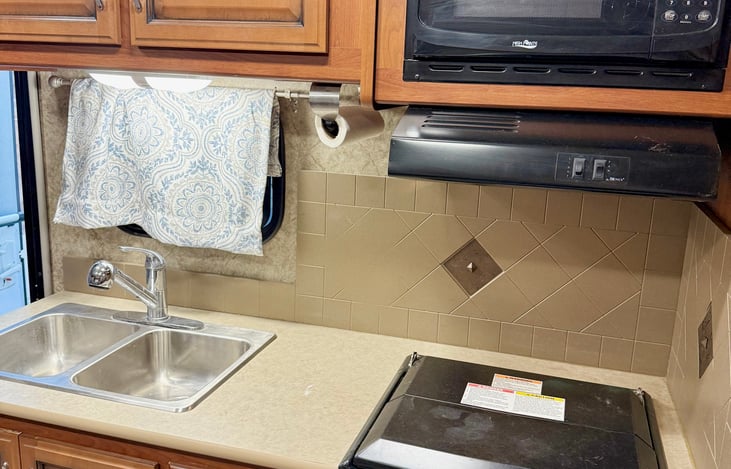 Kitchen with gas stove, oven, microwave.