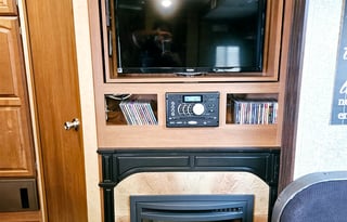 Large RV with outdoor kitchen, fireplace, and TVs