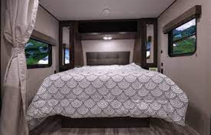 Queen size bed with closets on each side.  Under bed storage for folding chairs and table. We get regular compliments on the memory foam mattress.